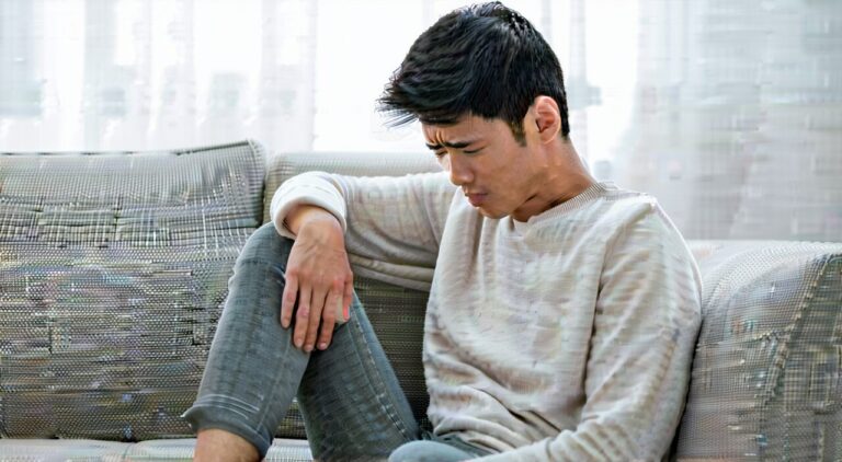 一位成年人在自然光下轻抚腹部,表现腹胀不适与中医调理主题