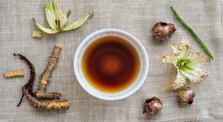 A bowl of Baihe Gujin decoction and medicinal herbs