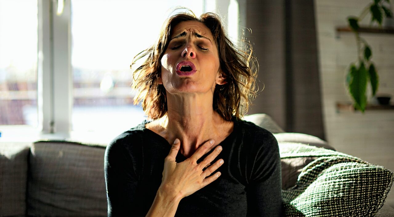 Woman with hand on chest, expressing chest discomfort