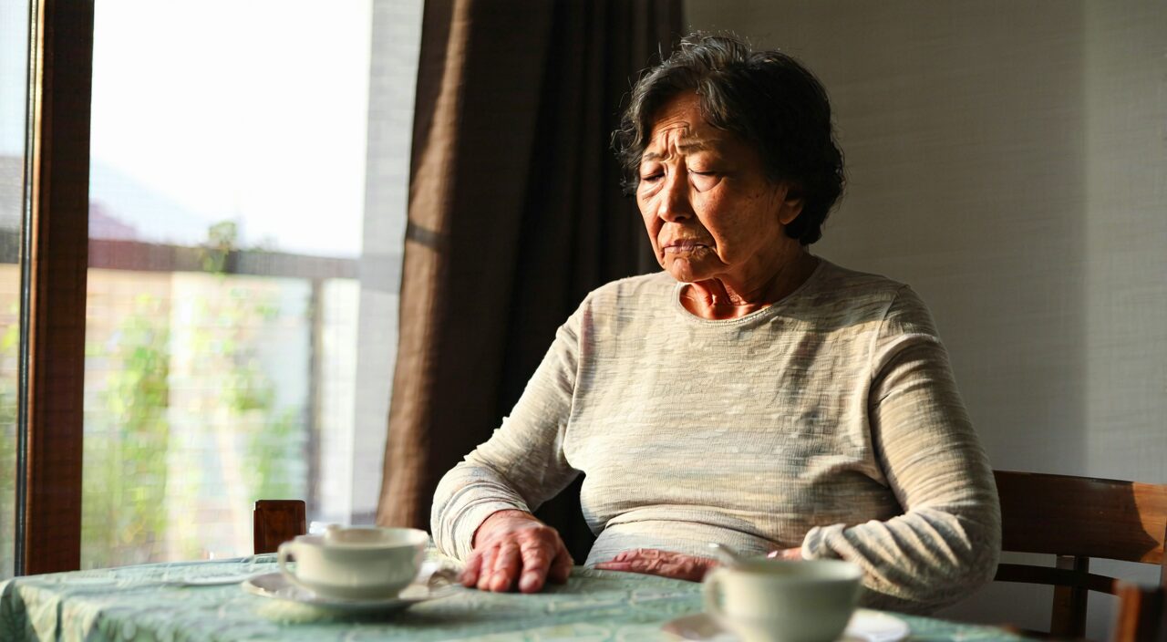 A person gently pressing the epigastric area with a slightly uncomfortable expression, illustrating the characteristic of epigastric fullness