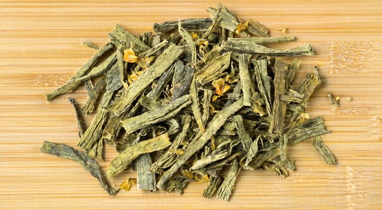 Close-up of dried patchouli herbal slices, showing visible square stems and broken green leaf pieces